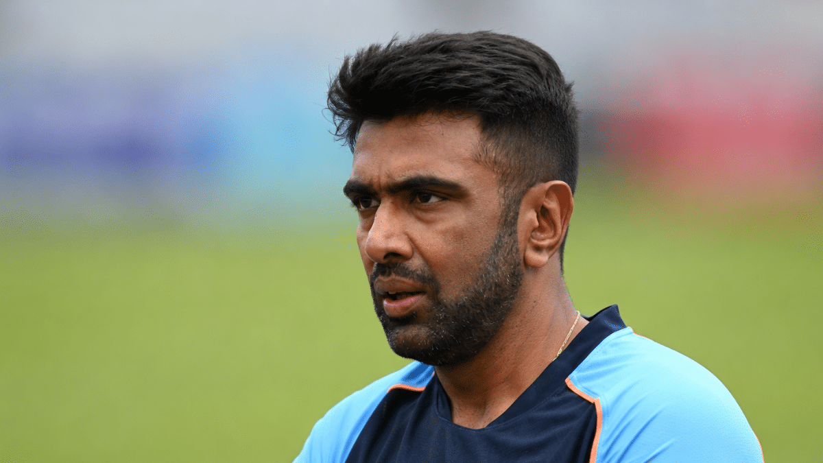 Ultra-realistic side-profile photograph of Ravichandran Ashwin at an India cricket training session, captured with a shallow depth of field and a softly blurred background.