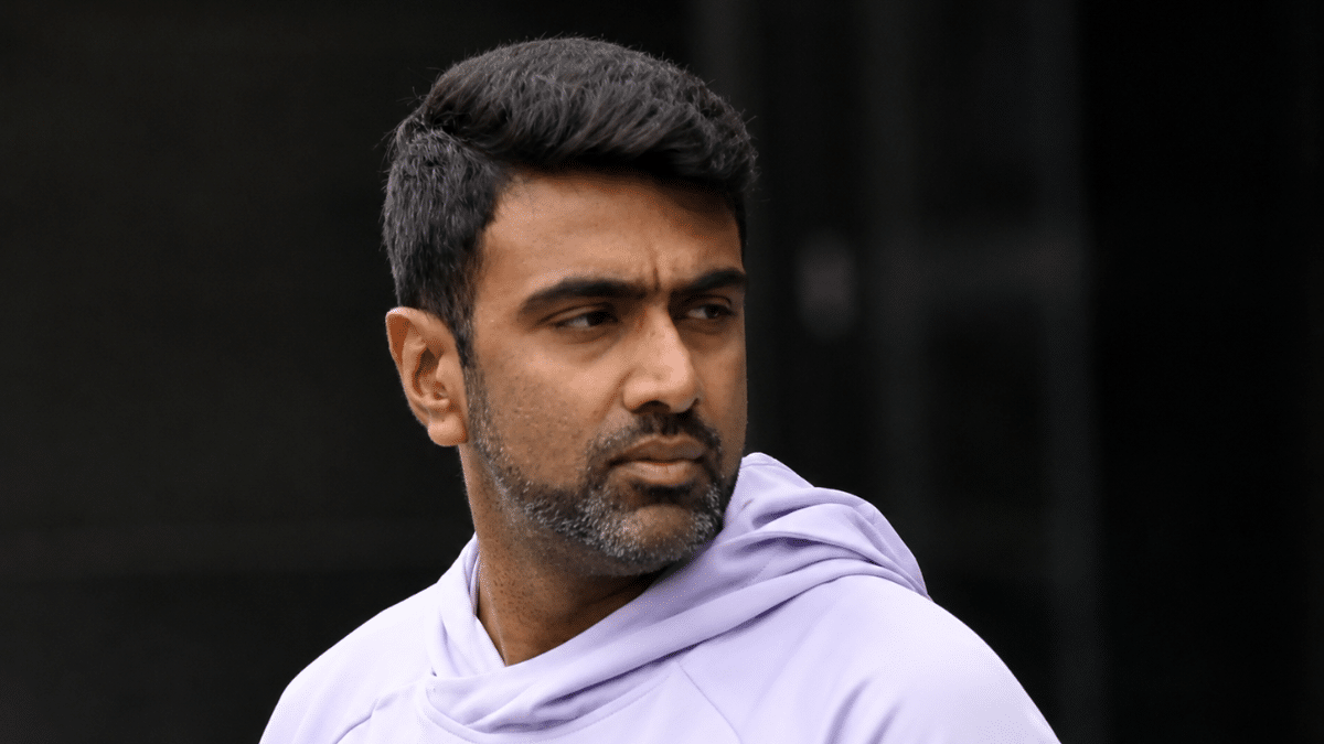 Ultra-realistic side-profile portrait of Ravichandran Ashwin in a casual hoodie, captured with shallow depth of field and a blurred background.
