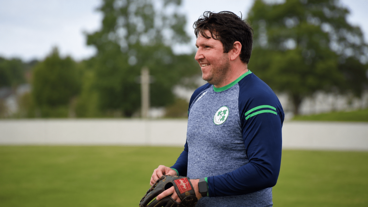 Gary Wilson smiling in Cricket training kit holding wicketkeeping glove