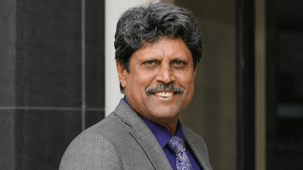 Ultra-realistic side-angle portrait of a former Indian cricketer Kapil Dev in a formal suit, captured with a professional editorial photography style.
