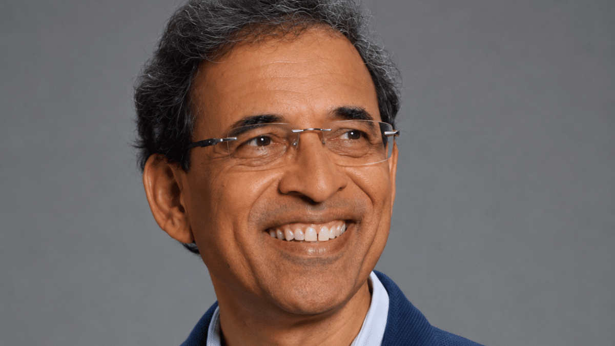 Harsha Bhogle wearing glasses in a navy blazer and light blue shirt