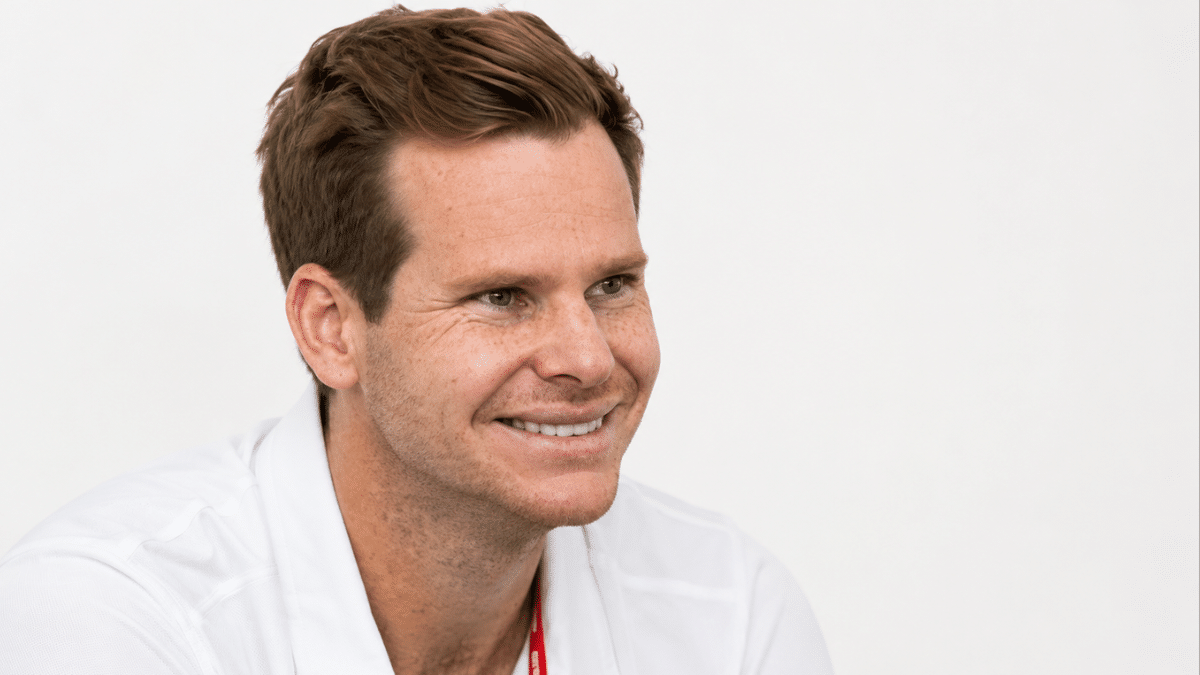 Australian cricketer smiling in a white polo shirt against a plain white background.