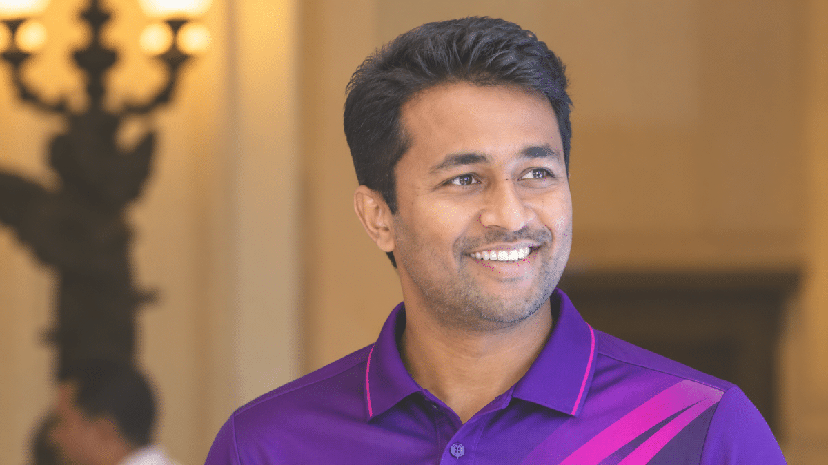 Pragyan Ojha, former Indian left-arm orthodox spinner, wearing a purple cricket polo shirt and looking to the right.