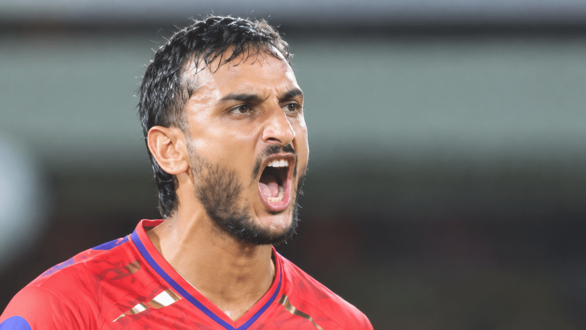 Shahbaz Ahmed, Indian cricketer, wearing a red cricket jersey during a match.