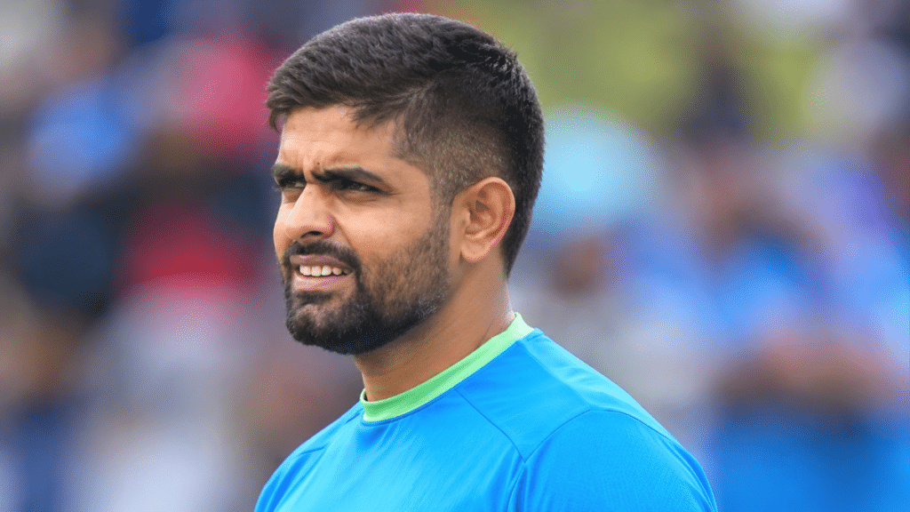 Babar Azam, Pakistan cricketer, wearing a blue cricket jersey.