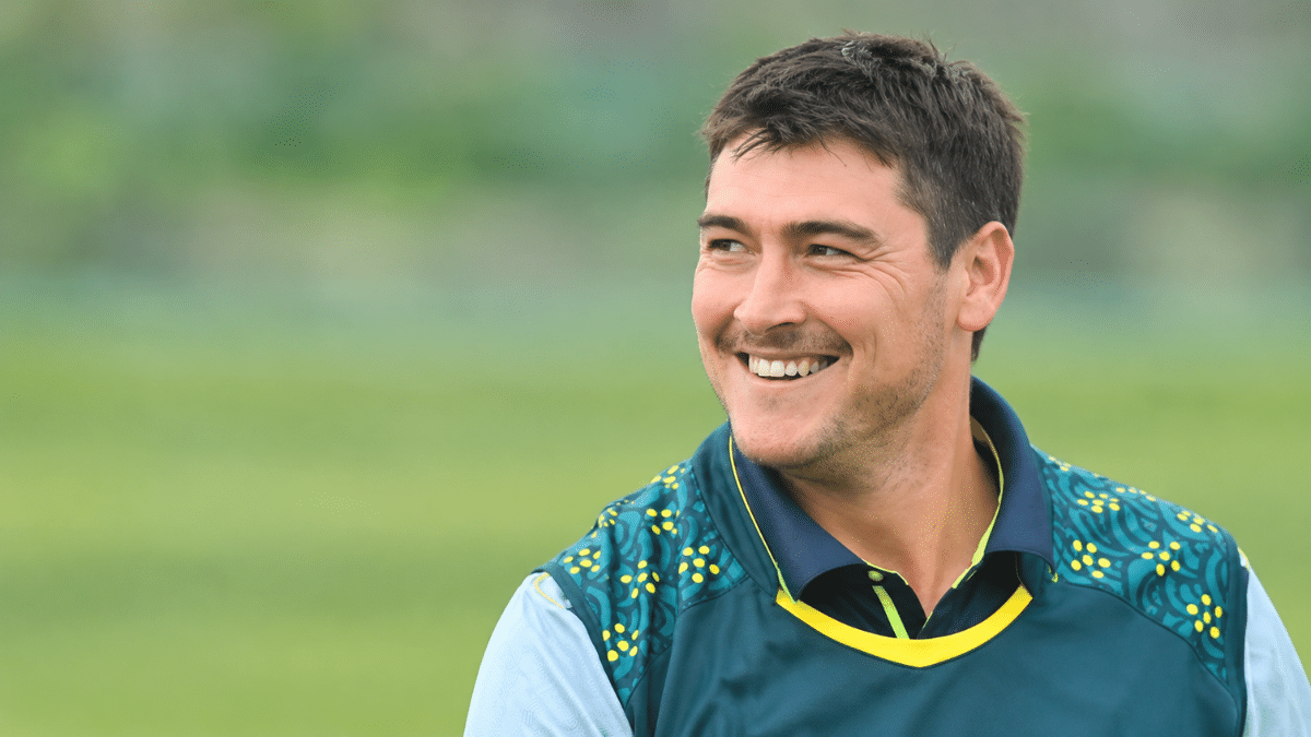 Matthew Renshaw, Australian left-handed batter, smiling in a dark teal cricket jersey and looking to the left.
