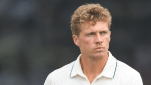 Nathan McSweeney, Australian cricketer and right-handed batter, wearing a white cricket shirt with green trim and looking to the right against a dark, blurred background.