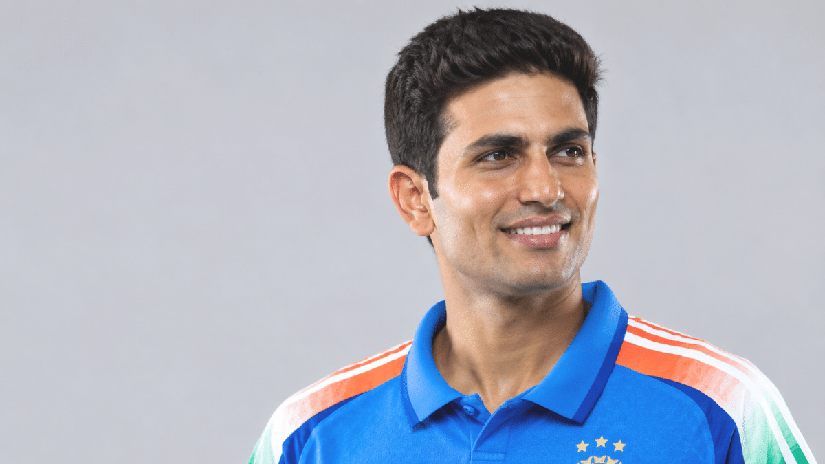 Shubman Gill, Indian right-handed batter, smiling in a blue cricket jersey and looking to the right.